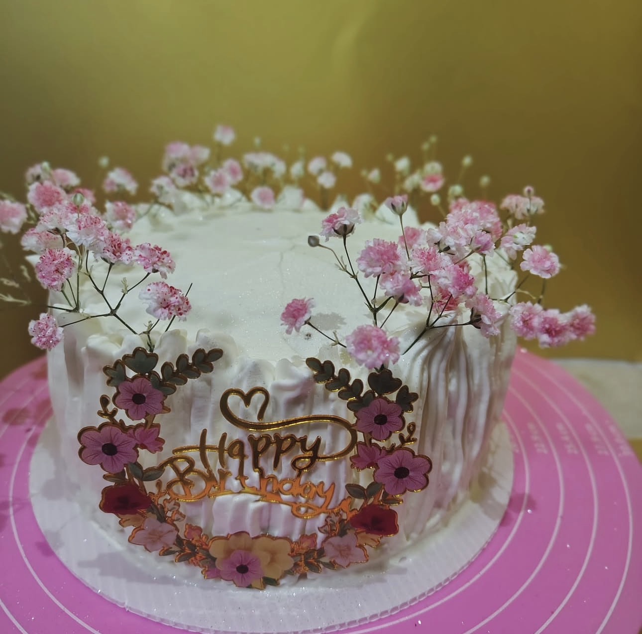 White birthday cake with pink flowers